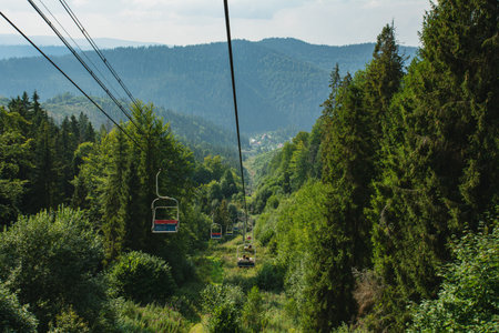 A cable car lift in the mountains in summer: a concept for travel, hiking, and ski tourismの写真素材