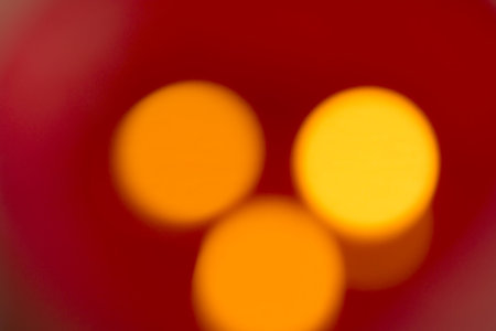 Lights - The indistinct flare of three candles with red background