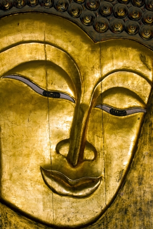 Buddha - A wooden golden Buddha face の写真素材