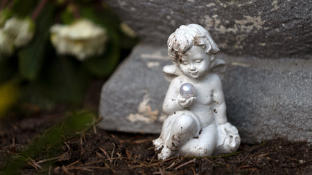 White sitting angel with pearl in handの写真素材