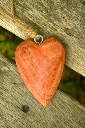 Heart shaped pendant on a wooden background. Selective focus.の写真素材