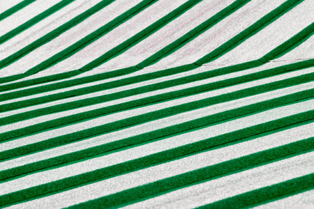 Green and white striped fabric as background, closeup. Textile patternsの写真素材