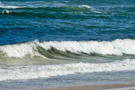 Sea waves breaking on the sandy beach, close-up. Backgroundの写真素材