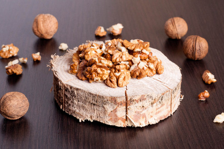 Walnut kernels and whole walnuts on wooden table, close up, horizontalの写真素材