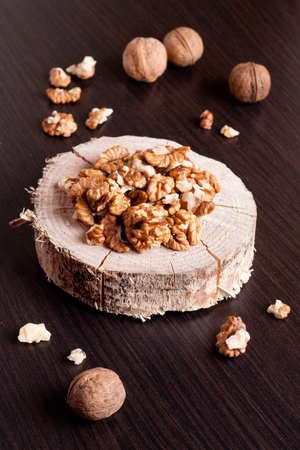 Walnut kernels and whole walnuts on wooden table, close up, verticalの写真素材