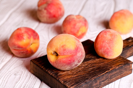 Ripe peaches in basket on wooden background, close up, horizontalの写真素材