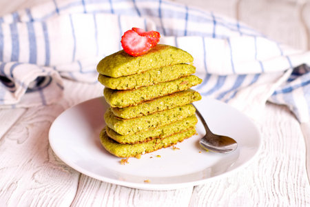green pancakes on a white plate for breakfast, horizontal, close up