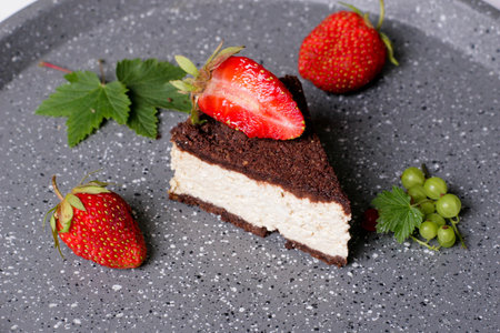 Delightful cocoa cake with cottage cheese filling with strawberries and mint, close up, horizontal, top viewの写真素材