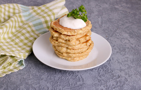 Vegetarian zucchini fritters or pancakes, served with greek yogurt, horizontal, close upの写真素材