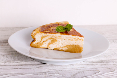 Pumpkin pie, cheese cake with cinnamon on a white plateの写真素材