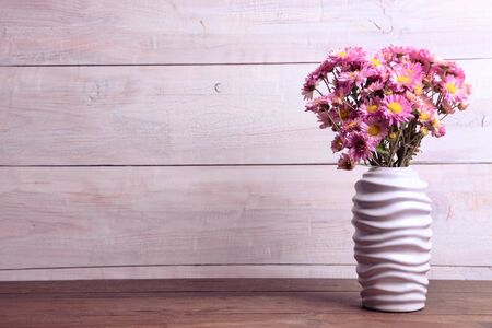 Beautiful bouquet of chrysanthemums in white vase on wooden background. Concept teacher's day. Copy space.の写真素材