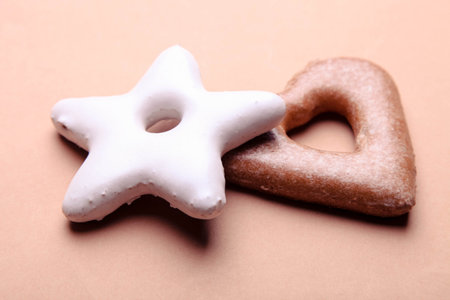 Star and heart shaped gingerbread cookies on brown paper background. New Year sweets concept.