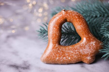 Glazed gingerbread next to a spruce branch on a marble background. New Year sweets concept.の写真素材