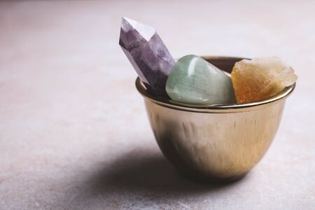 Mineral stones in a ritual bowl on a white background. Occultism concept.の写真素材