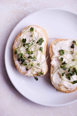 Toasts with cream and radish microgreen on a white background.の写真素材