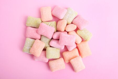 Pillows of multi-colored chewing gum on a pink background.の写真素材
