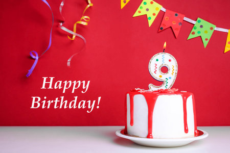 White cream cake with red icing and a candle on a red background. Birthday concept.の写真素材