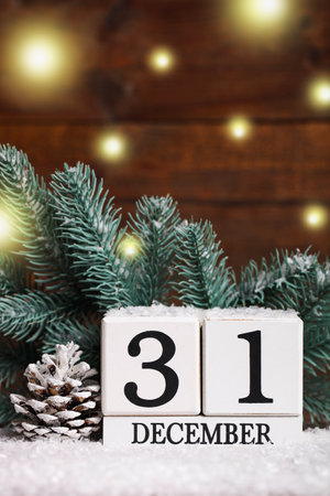 Perpetual calendar and fir branches on a wooden brown background. Christmas decor. Home decoration.の写真素材