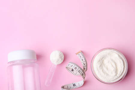 White protein powder and measuring tape on a pink background.の写真素材
