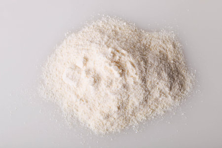 Heap of white protein powder on white background.