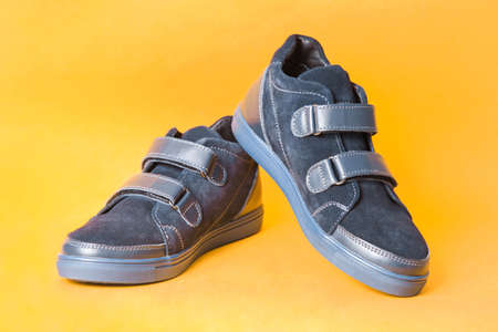 Pair of suede demi-season boots for boy on orange background.の写真素材