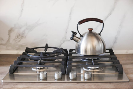Kettle is heated on built-in gas hob in modern kitchen.