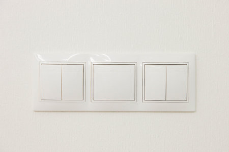 Mechanical light switch with five keys, mounted on a white wall.