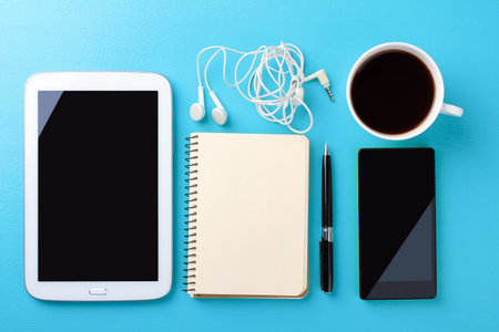 Gadgets and office supplies on a blue wooden background. workplace.の写真素材