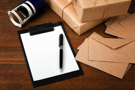 Parcels and envelopes with a stamp on a brown wooden background. delivery concept.の写真素材
