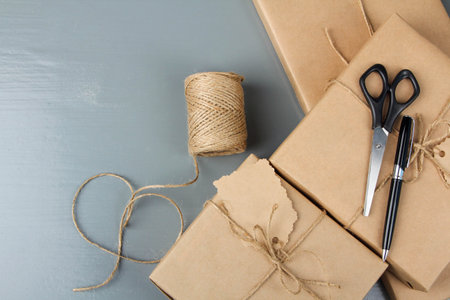 Gift wrapping in craft paper on a gray wooden background.