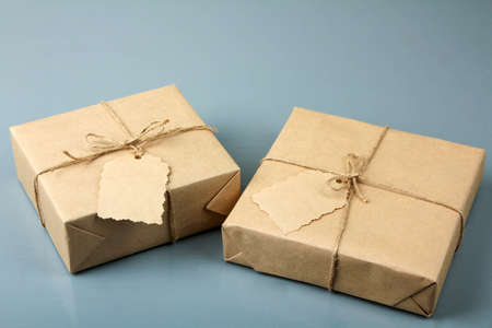 Two gifts in craft paper on a gray wooden background.の写真素材