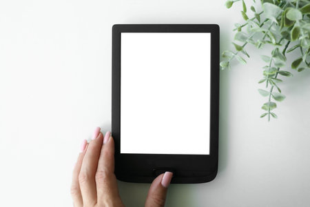 electronic book in woman's hand on gray background.