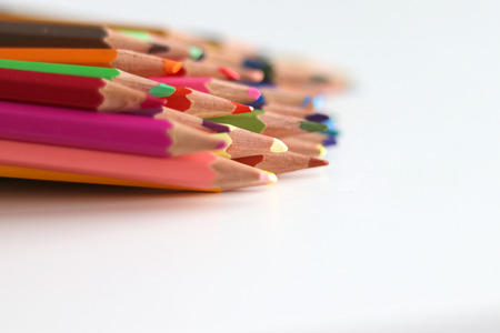 Bunch of colorful pencils lying on white backgroundの写真素材