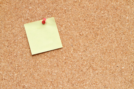 blank post it note pinned to a cork board / bulletin boardの写真素材