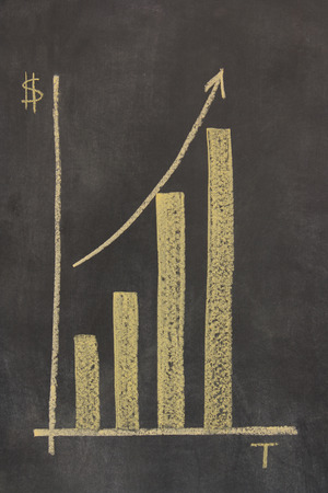 bar chart drawn on a chalkboard plotting time against money, with an arrow showing upward trendの写真素材