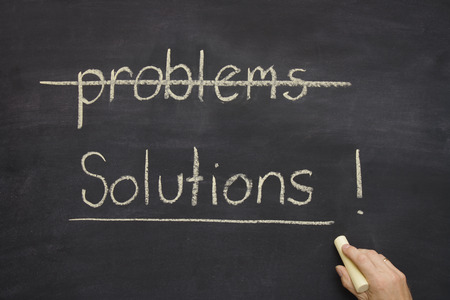 problems  solutions written on a blackboard  chalkboard with the word problems crossed out and solutions underlined.の写真素材