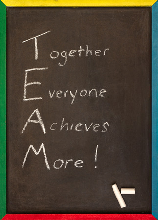 together everyone achieves more written on a chalkboard with a multi coloured wooden frameの写真素材