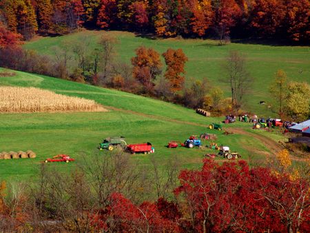 farmland landscape with truck tractors and hay balesの写真素材