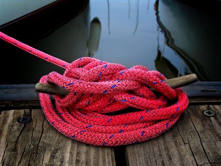 red boaters rope securing boat to dockの写真素材