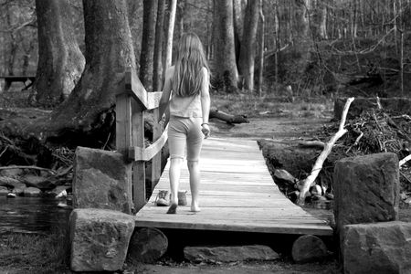 young girl walking on bridgeの写真素材