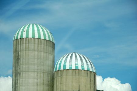 tops of twin silos against blue skyの写真素材
