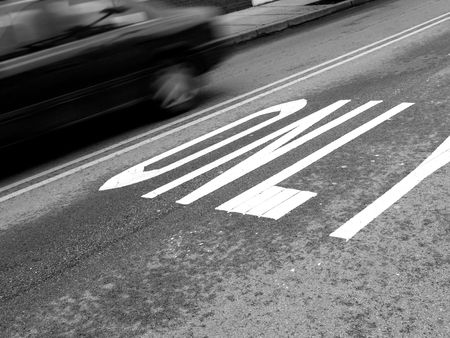 car traveling on city street with ' this lane only ' sign in frontの写真素材