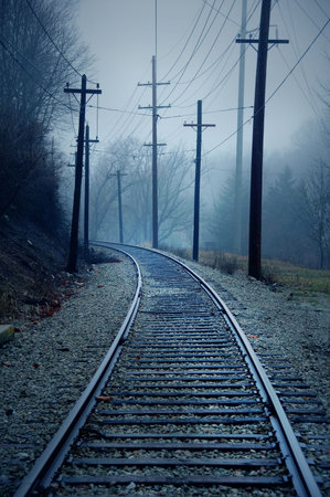 trolley track in the misty morning with telephone poles