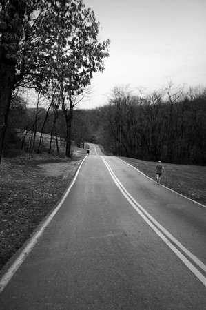 man and woman running on deserted roadの写真素材