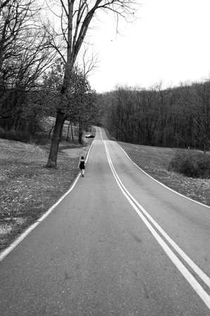 woman walking on deserted roadの写真素材