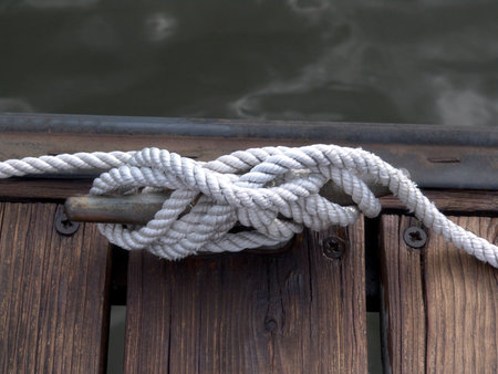 white boater's rope artistically coiled and attached to cleat on dock