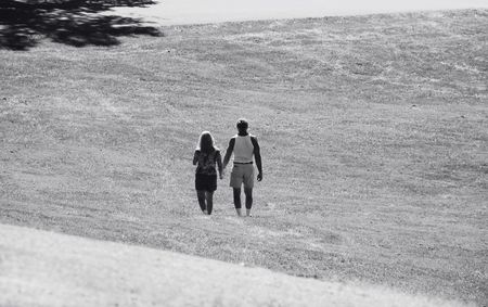 couple holding hands and walking in the parkの写真素材