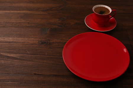 Empty red cup of coffee with a plate on the table. top viewの写真素材