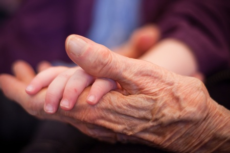 an old hand holding a baby handの写真素材