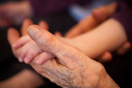 an old hand holding a baby handの写真素材